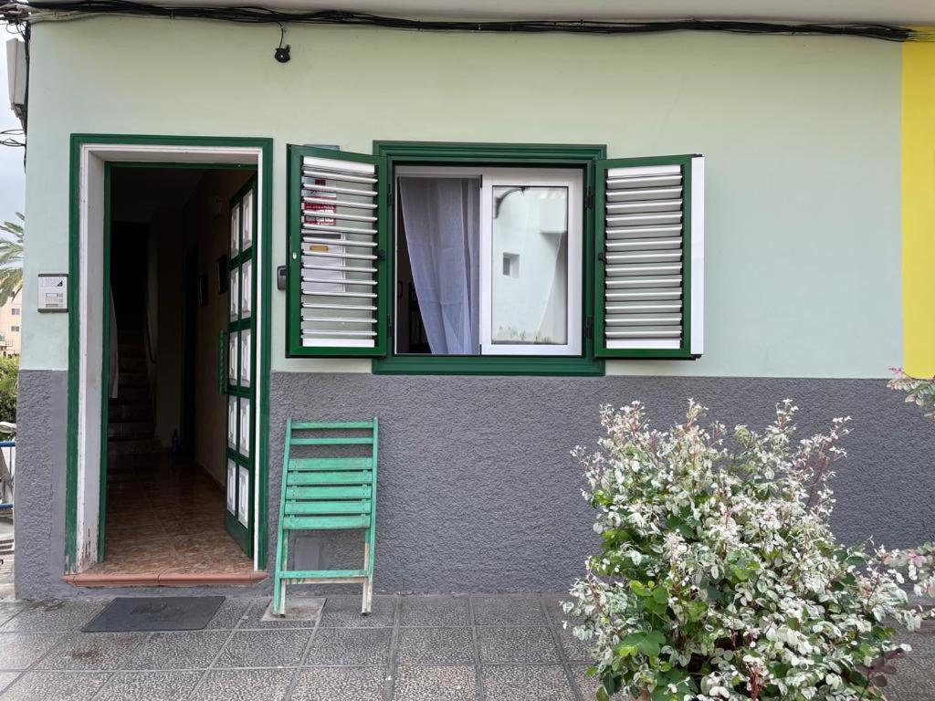 阿尔卡拉Casa Tortuga 1era linea de playa的绿椅,坐在房子外,有窗