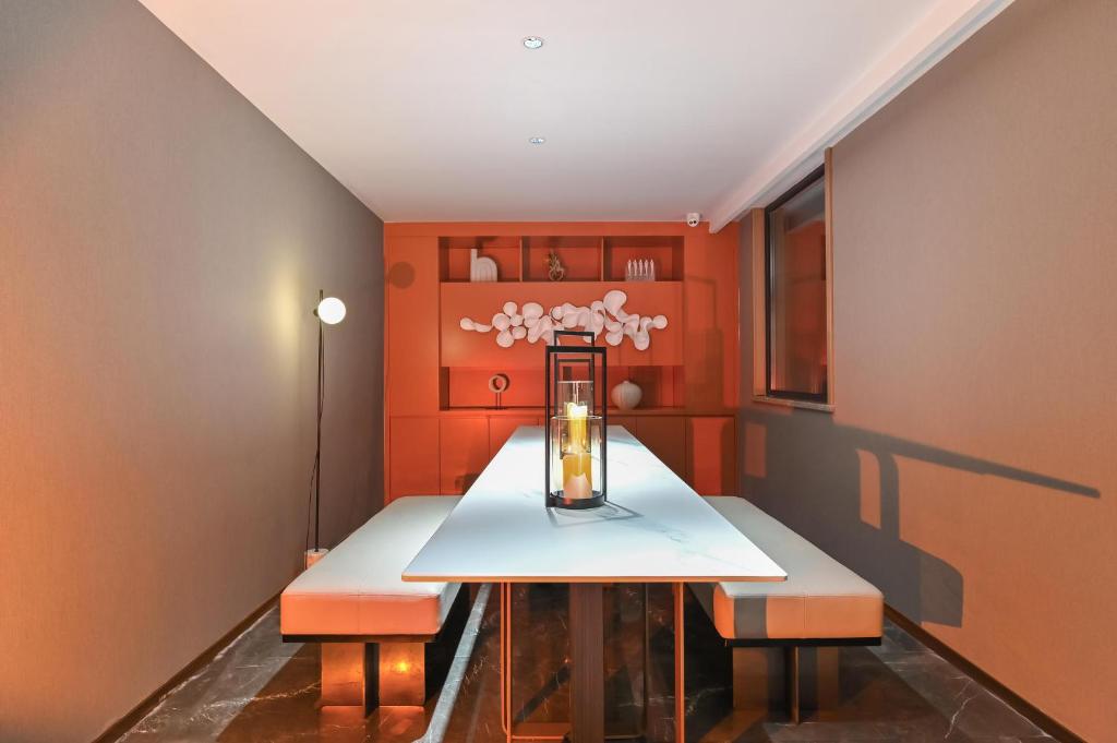吕梁吕梁中央公园亚朵酒店的一间拥有橙色墙壁、桌子和2个长凳的用餐室