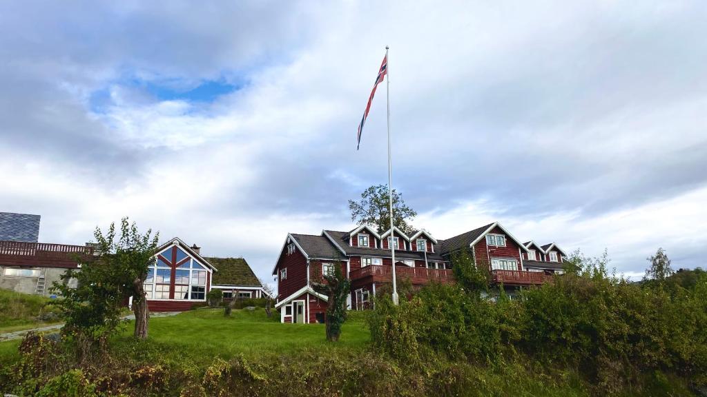 OsøyroBjørnafjorden Hotell的前面悬挂着旗帜的房子