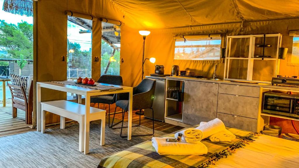 克兰尼蒂African Safari Canvas Lodge Tent Sea View的一间设有厨房和一张桌子的帐篷间