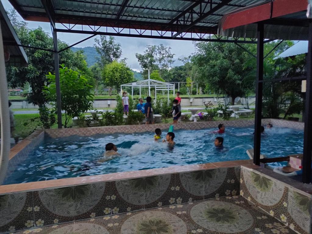 坤西育府Armthong Resort的一群人在游泳池里