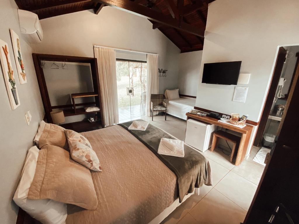 戈亚斯州上帕莱索波萨达瑞坎托格兰达巴斯酒店的一间带大床的卧室和一间客厅