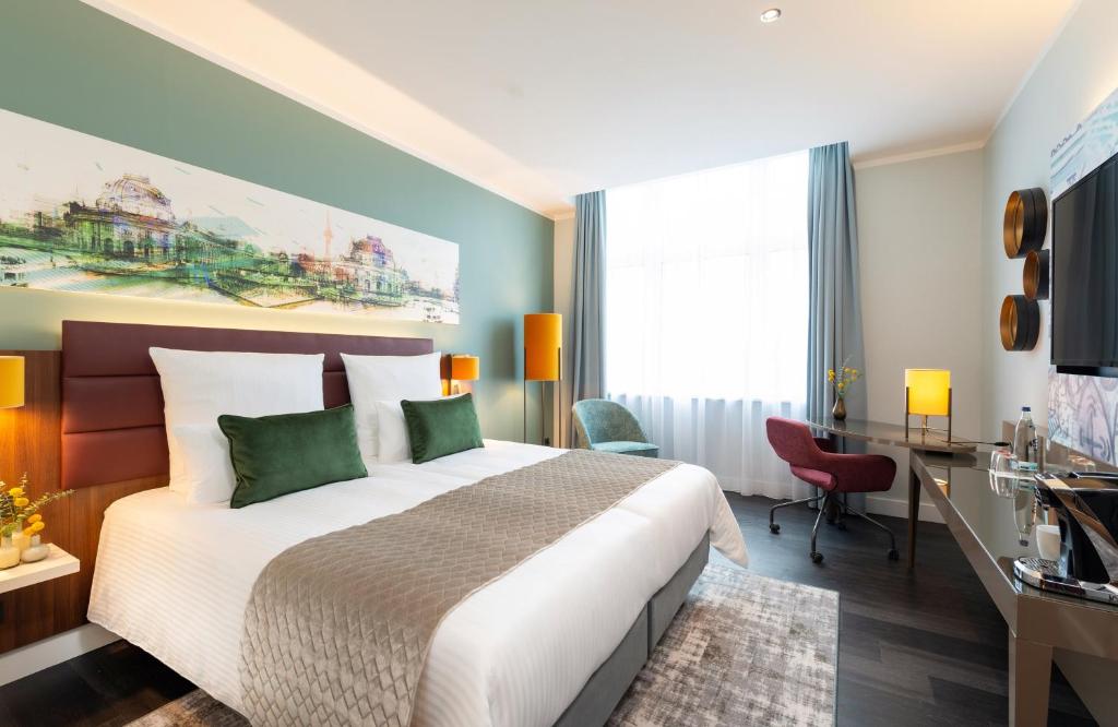 柏林柏林亚历山大广场莱昂纳多皇家酒店的配有一张床和一张书桌的酒店客房