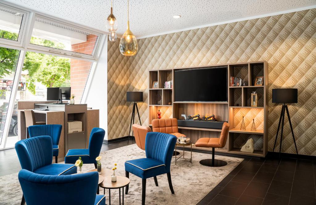 柏林柏灵莱昂纳多酒店的客厅配有电视和蓝色椅子