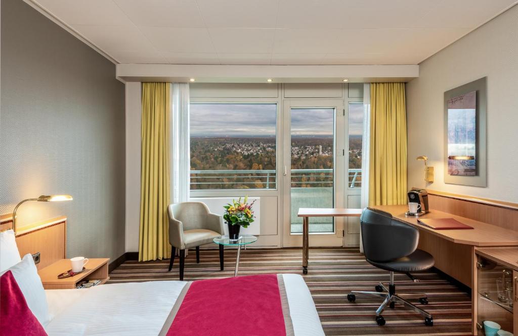 美因河畔法兰克福法兰克福莱昂纳多皇家酒店的配有一张床、一张书桌和一扇窗户的酒店客房
