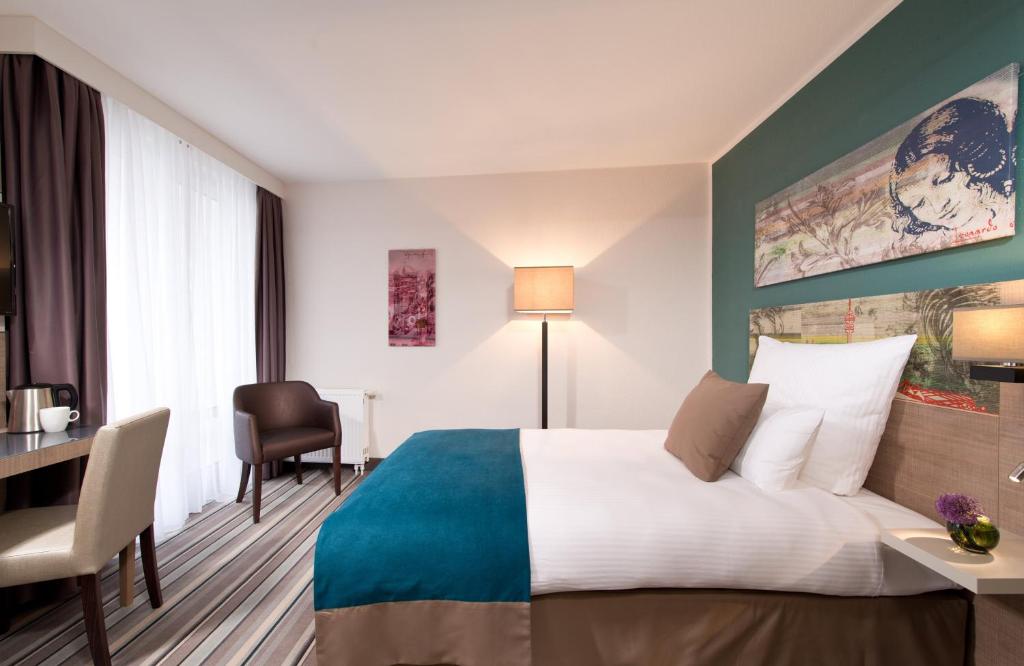 慕尼黑慕尼黑市奥林匹克公园莱昂纳多酒店的配有一张床和一张书桌的酒店客房