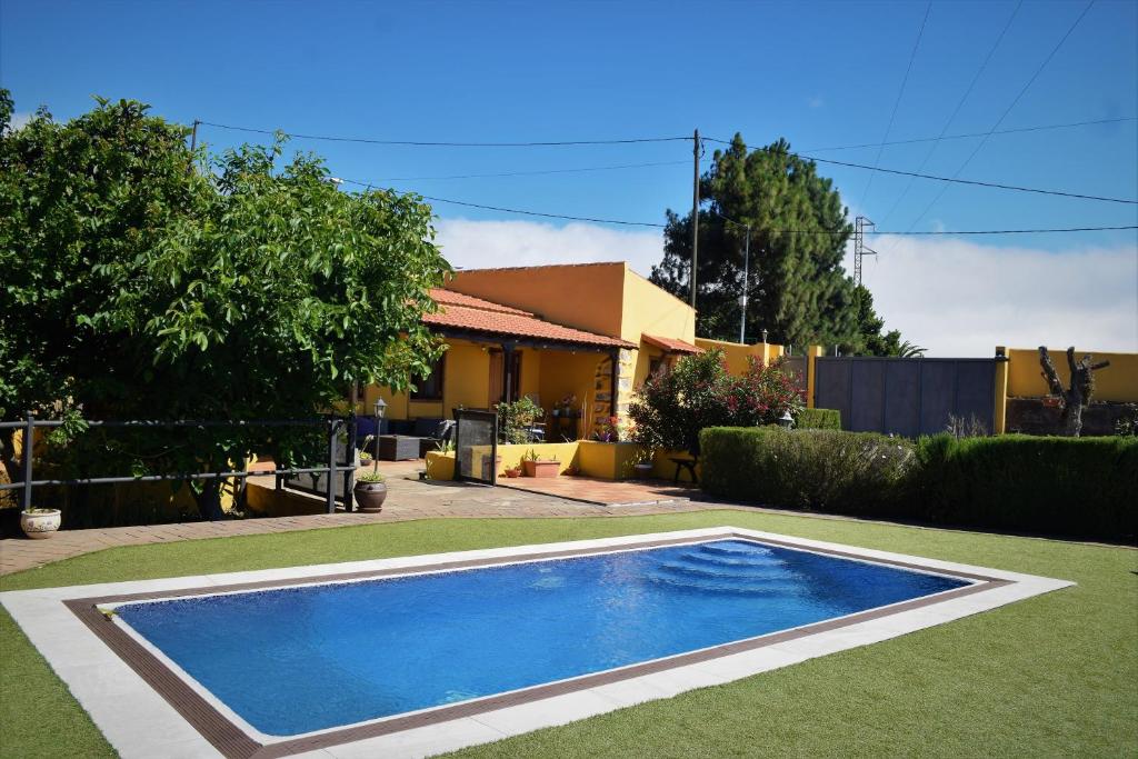 El Rosario芬卡拉马加德拉酒店的一座房子的院子内的游泳池