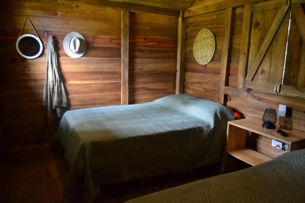 孔斯坦萨Pinar del Valle - Glamping en el Bosque - Propiedad Completa en Constanza的木制客房内的一间卧室,配有一张床