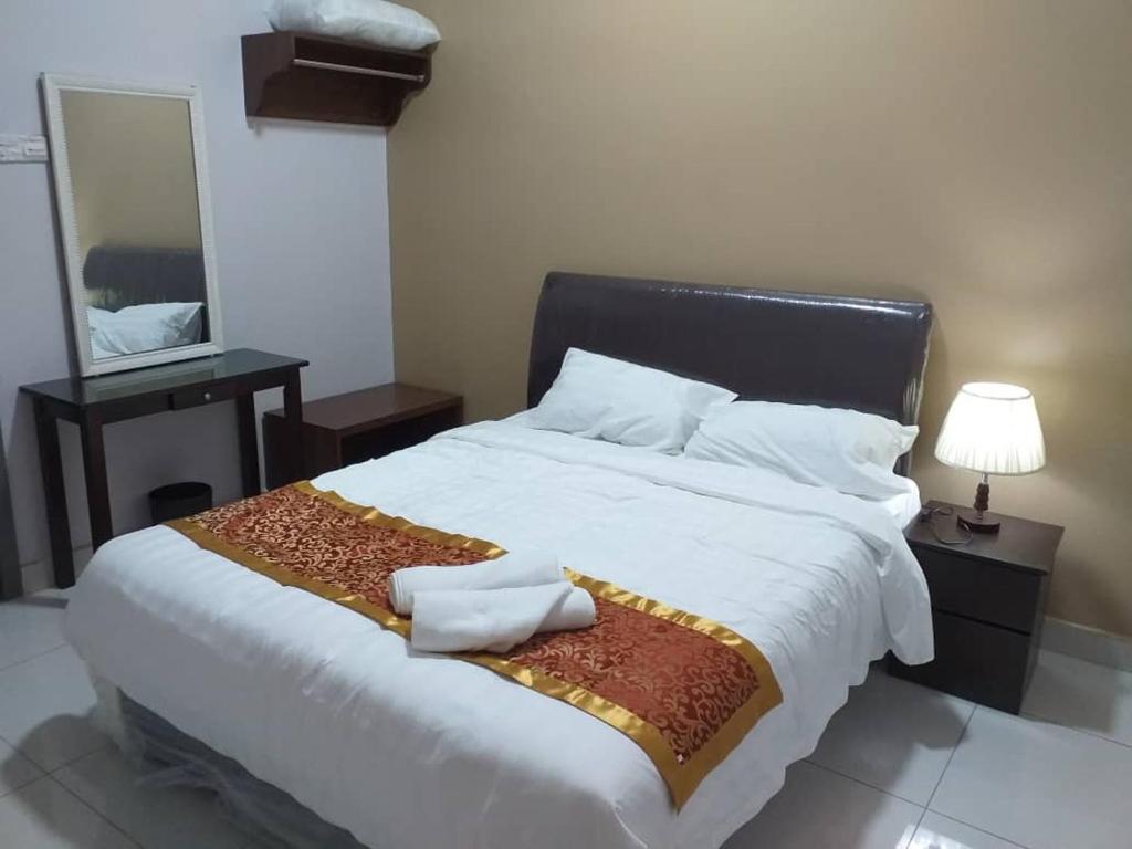 拉布安Labuan Paragon Apartment - 3 rooms的卧室配有一张带镜子的白色大床