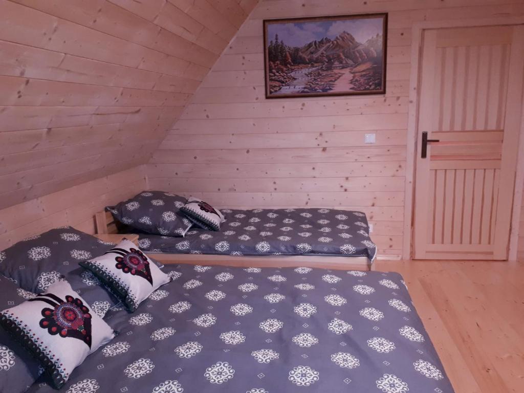 新塔尔格Domek w górach pod Jodłami的阁楼上的卧室配有两张床
