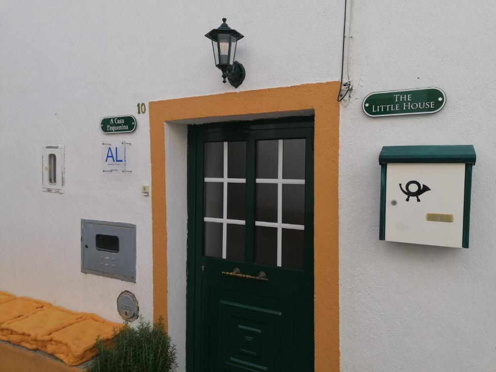 马尔旺A Casa Pequenina - Escusa, Marvão的通往白色建筑的门,有绿色的门