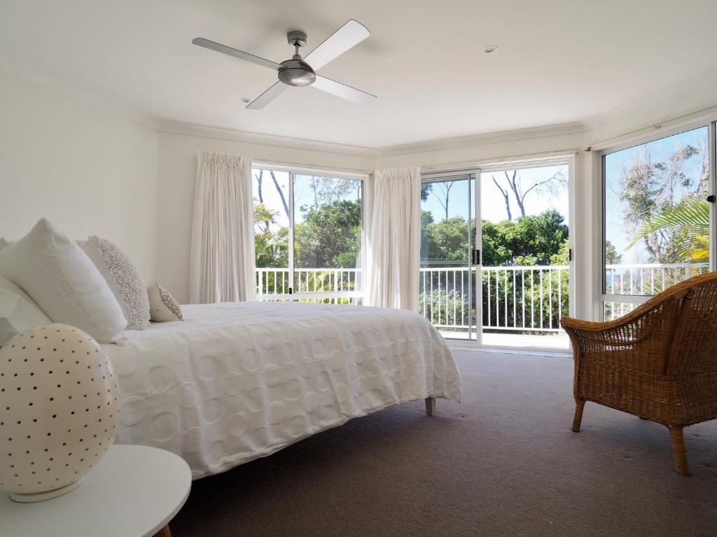 科夫斯港Beachfront Retreat - Ducted Air - Free Wifi的卧室配有白色的床和吊扇