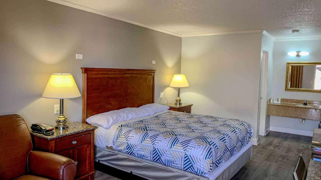 纽波特纽斯Motel 6 Newport News, VA – Fort Eustis的一间卧室配有一张床、一个水槽和两盏灯。