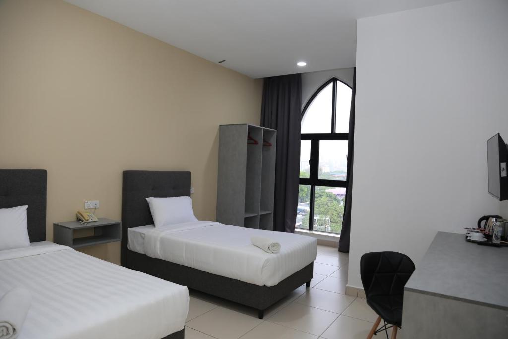 吉隆坡Pusat Belia Antarabangsa的酒店客房设有两张床和窗户。