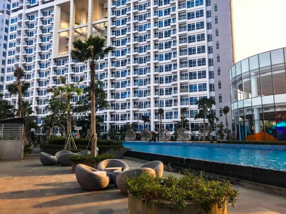 雅加达Studio Apartment at Puri Mansion West Jakarta的一座高楼前的带游泳池的酒店