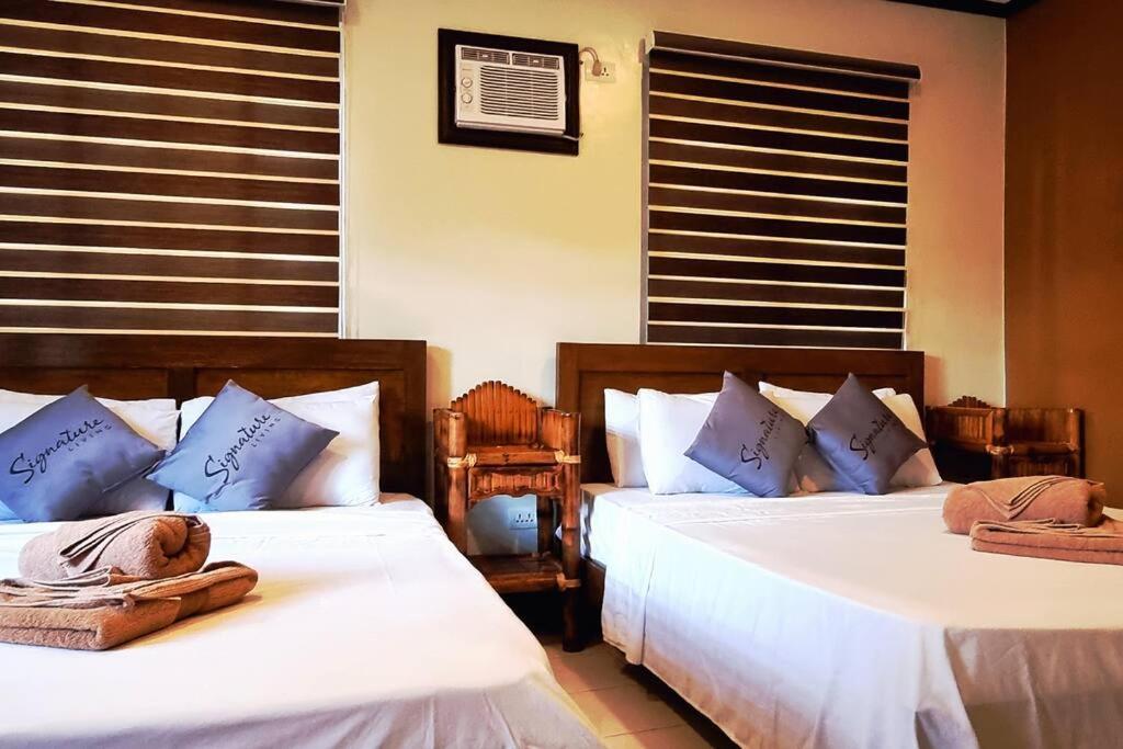 长滩岛Balay sa bukid (1bedroom)的一间卧室配有两张带毛巾的床