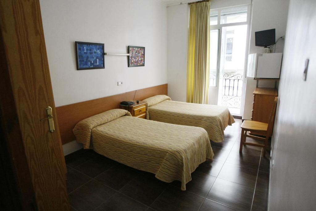 阿利坎特圣费尔南多旅馆 的酒店客房设有两张床和窗户。