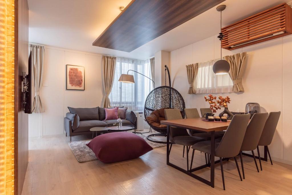 大阪Bijou Suites Sorriso的客厅配有桌子和沙发