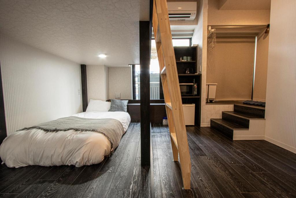 横滨GRAND CAVE MOTOMACHI的一间卧室设有一张床,楼梯位于卧室内