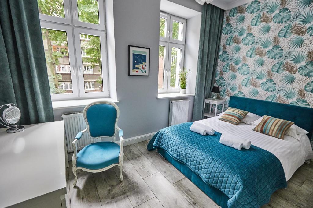 霍茹夫Niebieski Apartament DE LUX dla 4 osób Chorzów Katowice的一间卧室配有蓝色的床和蓝色椅子