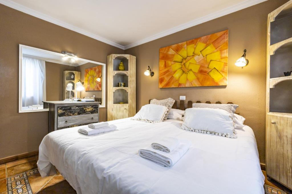 洛斯雷亚莱霍斯Bonito y acogedor apartamento con terraza的卧室配有带毛巾的大型白色床