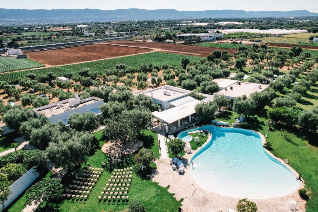 萨维勒特里Masseria Don Luigi-Luxury Farmhouse的享有带游泳池和树木的度假村的空中景致