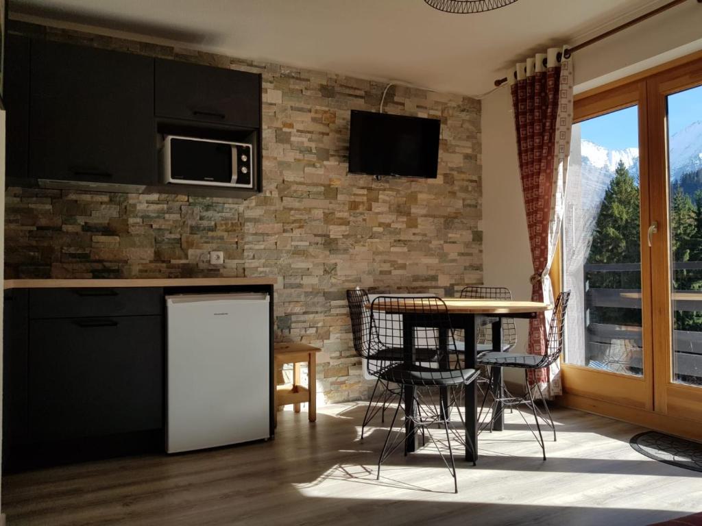 圣热尔韦莱班Appartement Saint Gervais les Bains piscine et vue imprenable Mont Blanc的厨房配有柜台和桌椅