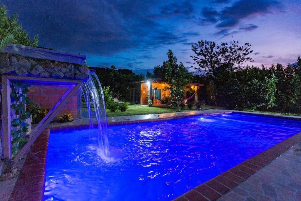 RozoLAS ORQUIDEAS的夜间后院的瀑布游泳池