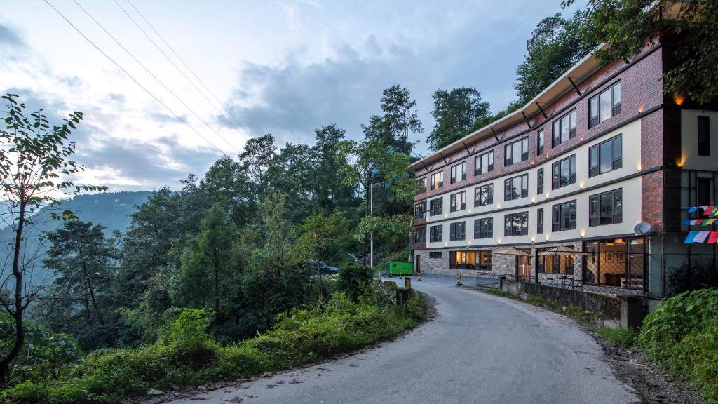 甘托克Indra Mandala,Gangtok - AM Hotel Kollection的山丘上建筑物旁的土路