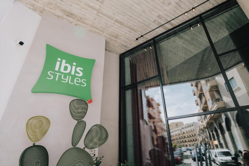 圣保罗湾城ibis Styles ST Pauls Bay Malta的大楼一边有商业标志