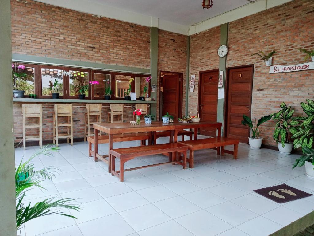棉兰Bua Guest House的庭院设有长椅、桌子和酒吧