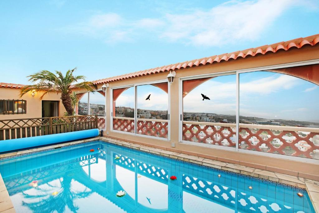 拉拉古纳Apartament Studio Petite Paradise的天空中鸟居的阳台上的游泳池