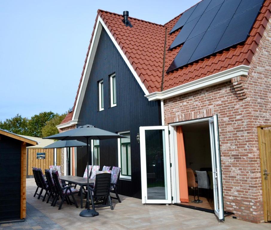 佐特兰德Luxe vakantievilla Zoutelande的房屋设有太阳能屋顶,配有桌椅