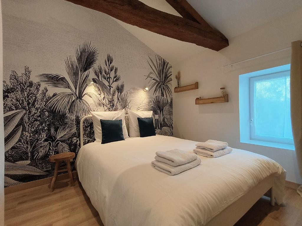 马孔Chez Emma et Louise - Maison individuelle avec stationnement的一间卧室配有带毛巾的床