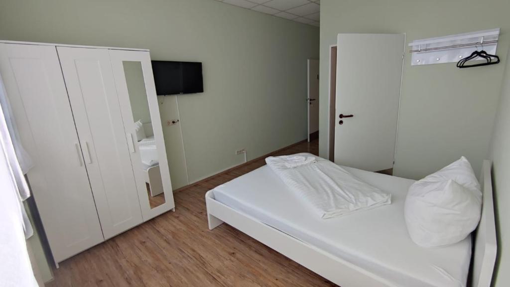 拉姆斯泰因-米森巴赫3 Bett Zimmer的卧室配有白色的床和镜子
