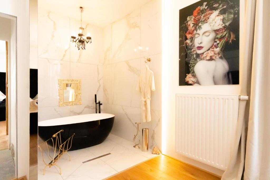 维也纳XuBa ApartmentRooms Messe Wien Prater的浴室设有黑色浴缸和白色瓷砖