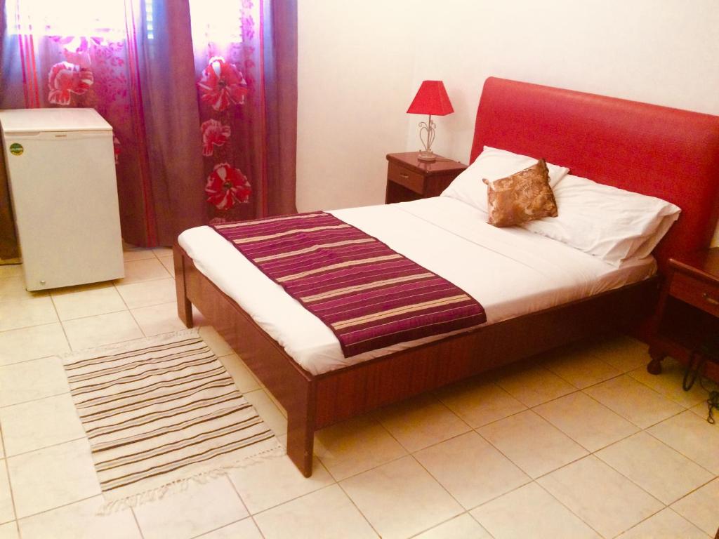 吉布提HOTEL ALIA的一间卧室配有一张红色床头板的床