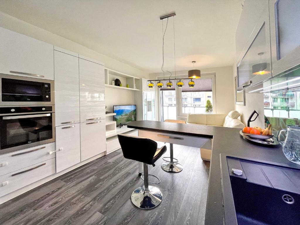 布拉格British Quarter Apartments的厨房配有白色橱柜和黑色台面