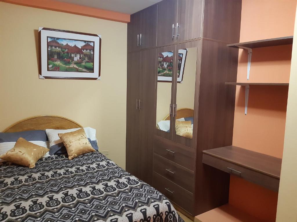普诺Hostal Vista al Lago Titicaca Puno的一间卧室配有一张床和一个木制橱柜
