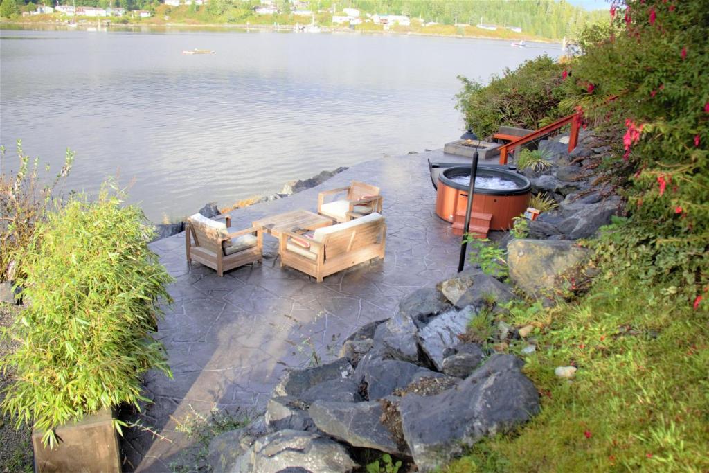 尤克卢利特Salt Loft - Oceanfront, Hot Tub And Firepit!的两张长沙发,水边有一个火坑