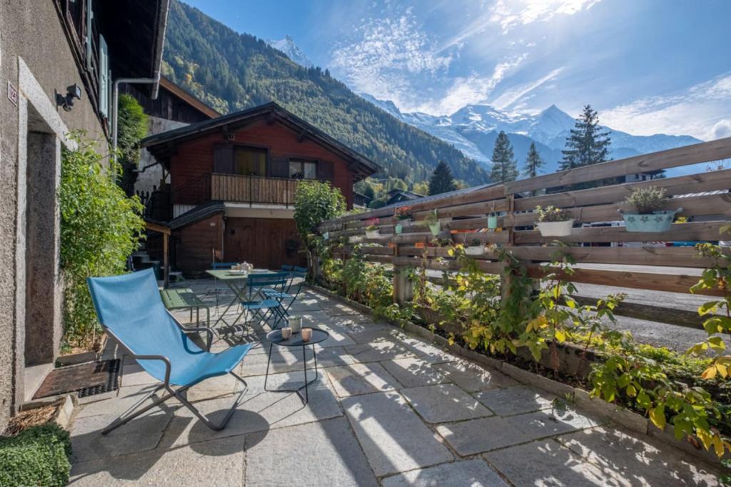 夏蒙尼-勃朗峰Loft-chalet with exterior and view in Chamonix的庭院设有蓝色椅子、桌子和围栏