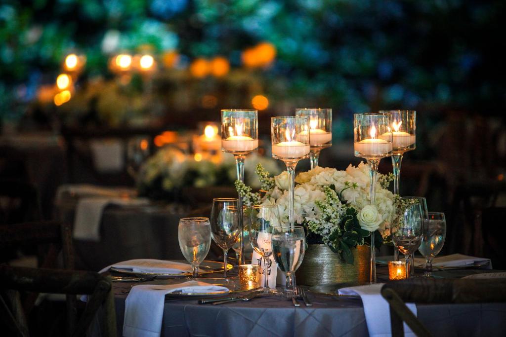 圣地亚哥Kimpton Alma San Diego, an IHG Hotel的一张桌子,上面放着蜡烛和白色的花朵及眼镜