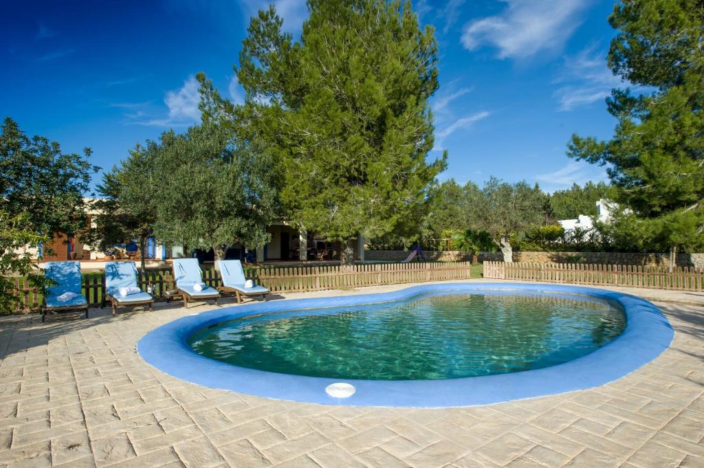 伊维萨镇卡尔拉度假屋的一个带两把椅子和围栏的游泳池
