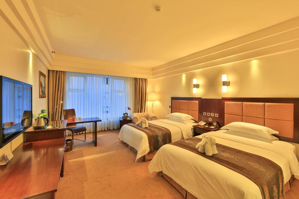 成都成都金府华美达大酒店的酒店客房设有两张床和电视。