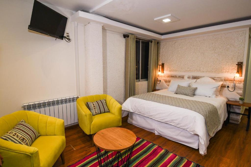 乌尤尼Cielo & Sal Hotel的酒店客房,配有一张床和两把椅子