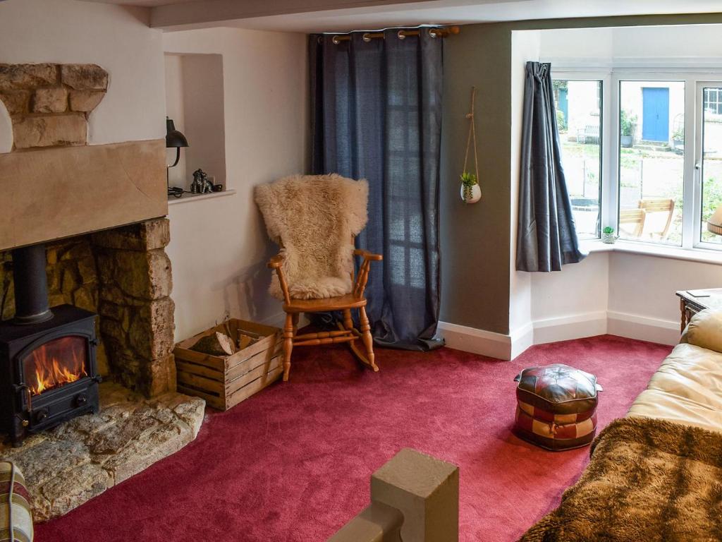 DudbridgeAshgrove Cottage的客厅设有壁炉和椅子