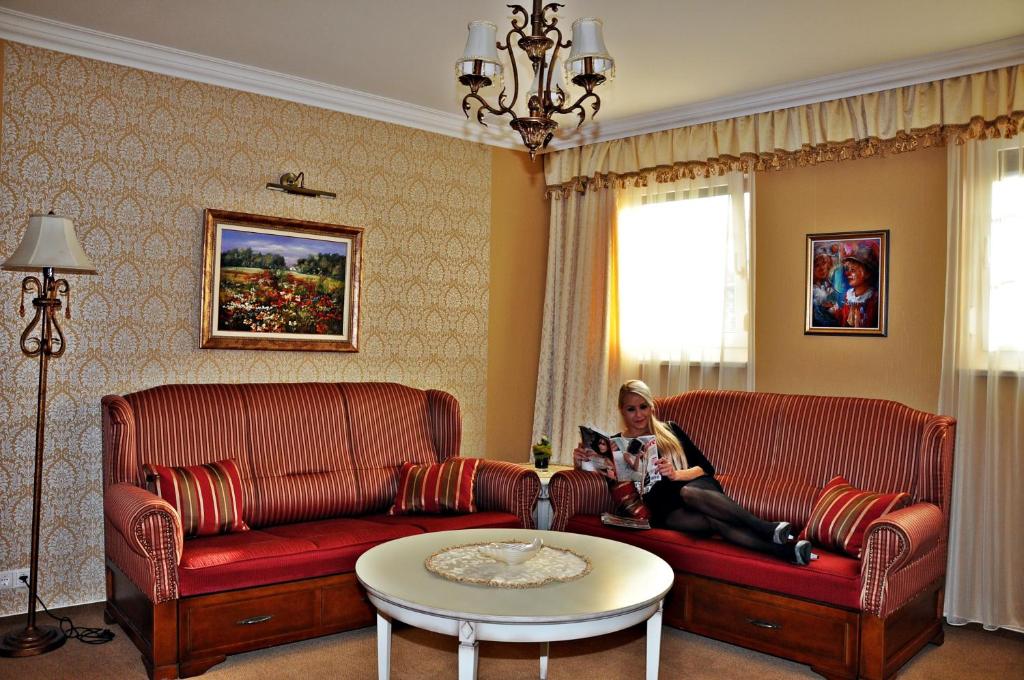 帕波Hotel Villa Classica的坐在客厅沙发上的女人