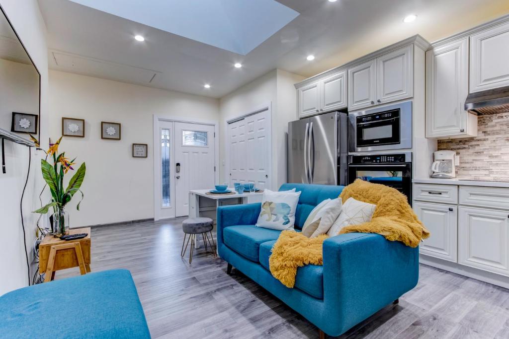 圣马特奥市Marbella Lane - Bright and Cozy Home near SFO的一间带蓝色沙发的客厅和一间厨房