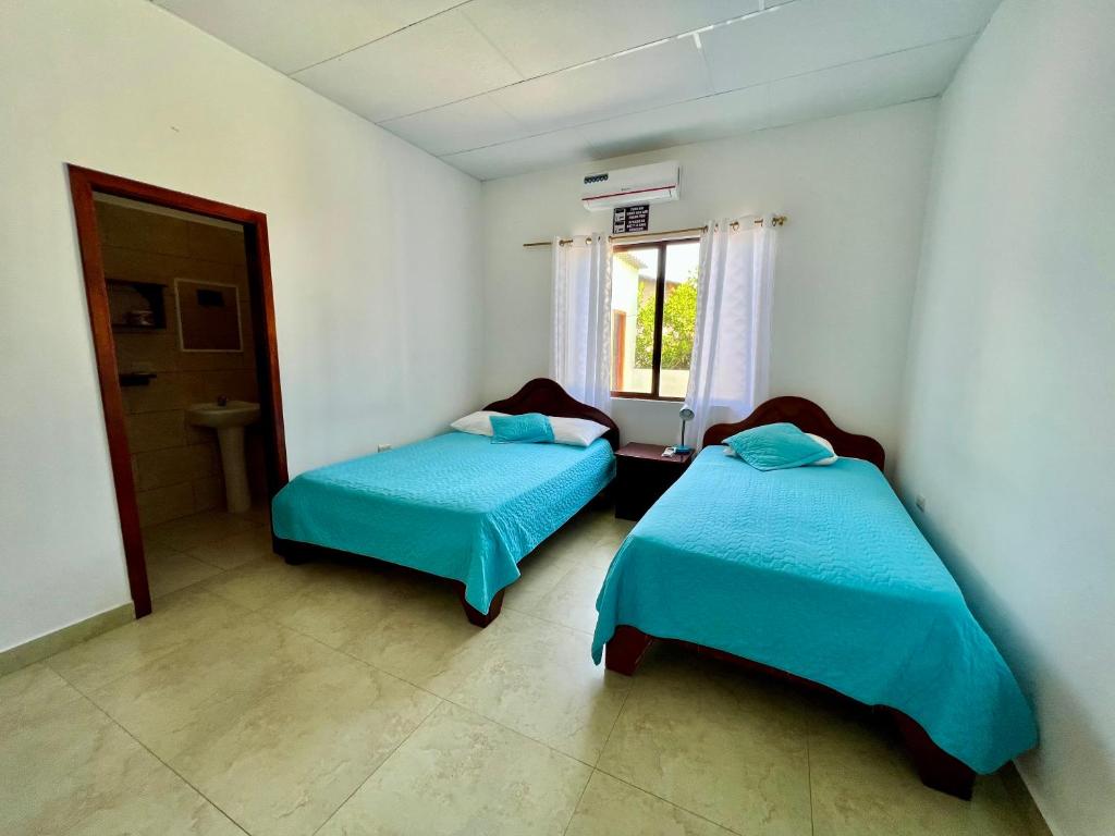 比亚米尔港Hostal Punta Arena的客房设有两张床和窗户。