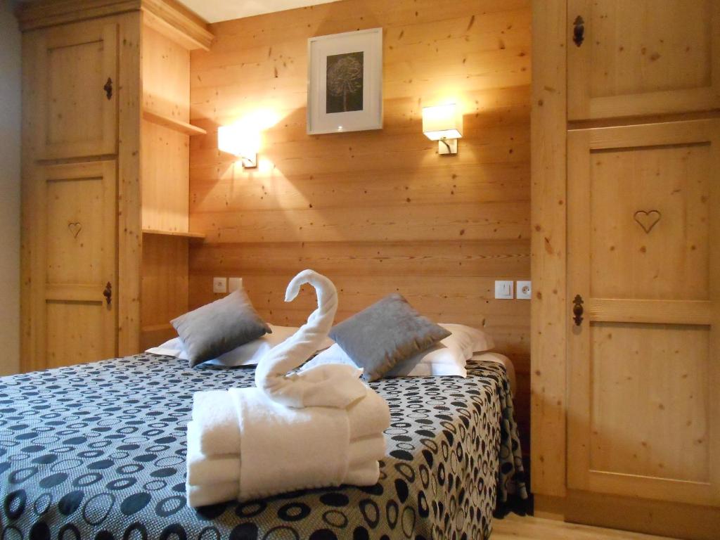 托讷Hôtel et appart'hôtel de l'Hermitage的一间卧室配有一张用毛巾制成的天鹅床。